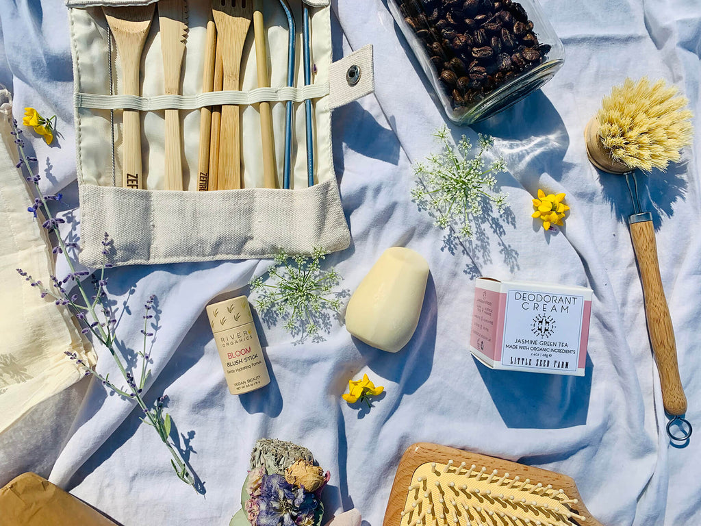 zero waste products on a sheet including compostable brushes, deodorant cream, hibar solid shampoo bar